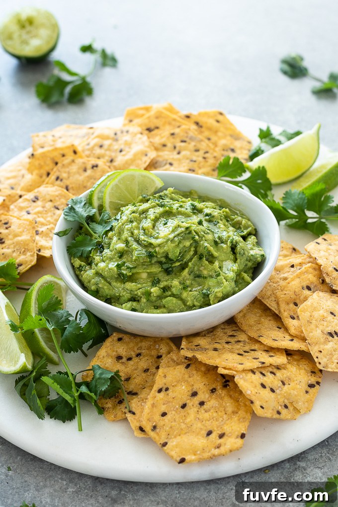 Homemade Guacamole with Lime, Cilantro and Jalapeño 3 Homemade guacamole in white bowl with lime and cilantro