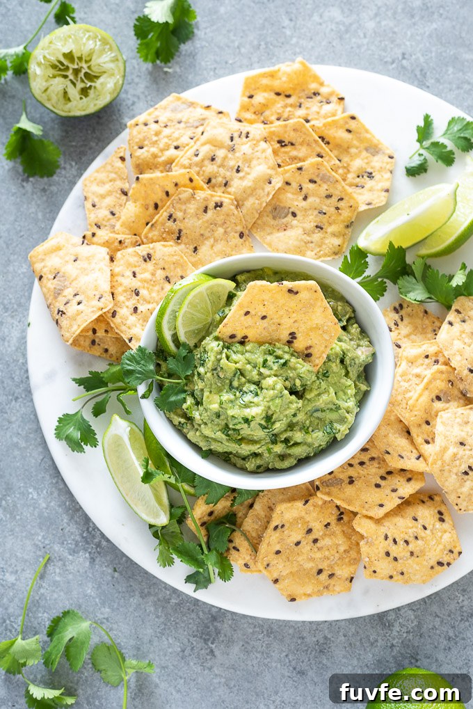 Homemade Guacamole with Lime, Cilantro and Jalapeño 8 Homemade guacamole with a chip dipped into the center