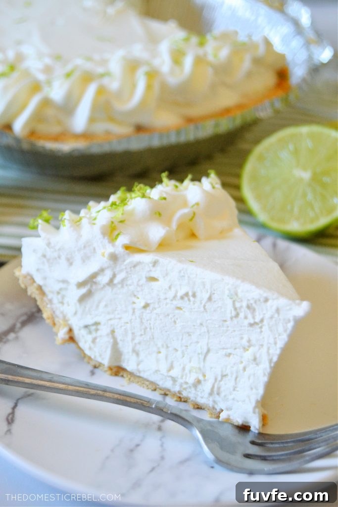 No-Bake Margarita Pie Recipe: Creamy Lime Cocktail Dessert 5 a piece of margarita pie on a white plate with a silver fork