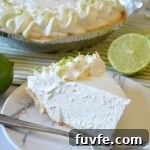 a piece of no bake margarita pie on a white plate with a fork and a lime wedge