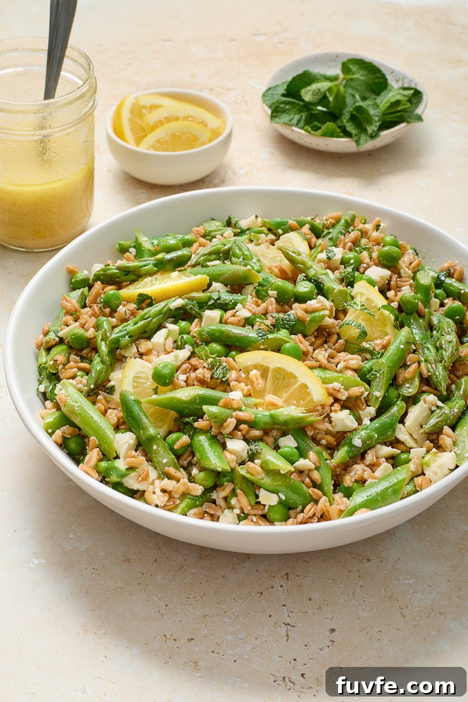 Spring Farro Salad with Feta, Peas and Lemon 6 Spring Farro Salad with Feta in a serving bowl with lemon slices.