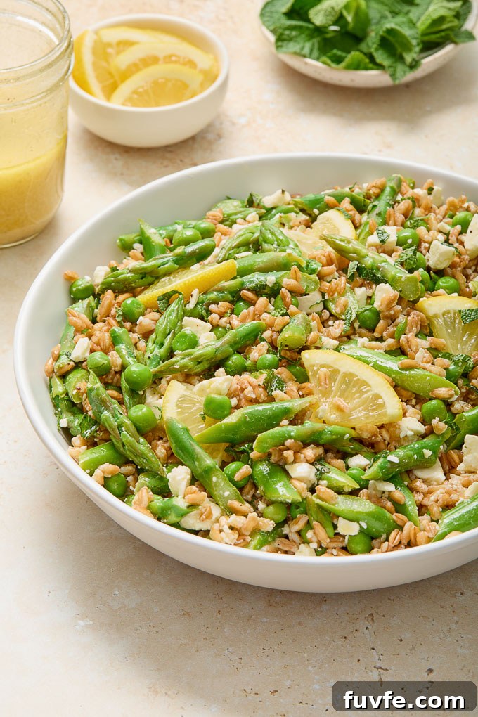 Spring Farro Salad with Feta, Peas and Lemon 7 Spring farro salad in a bowl with dressing and mint alongside
