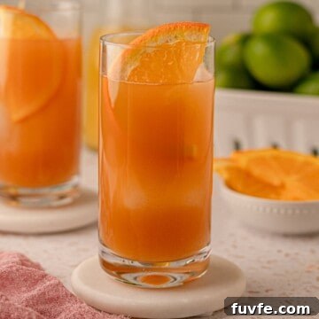 Authentic Jamaican Rum Punch Recipe for Tropical Cocktails 11 A cocktail garnished with an orange slice.