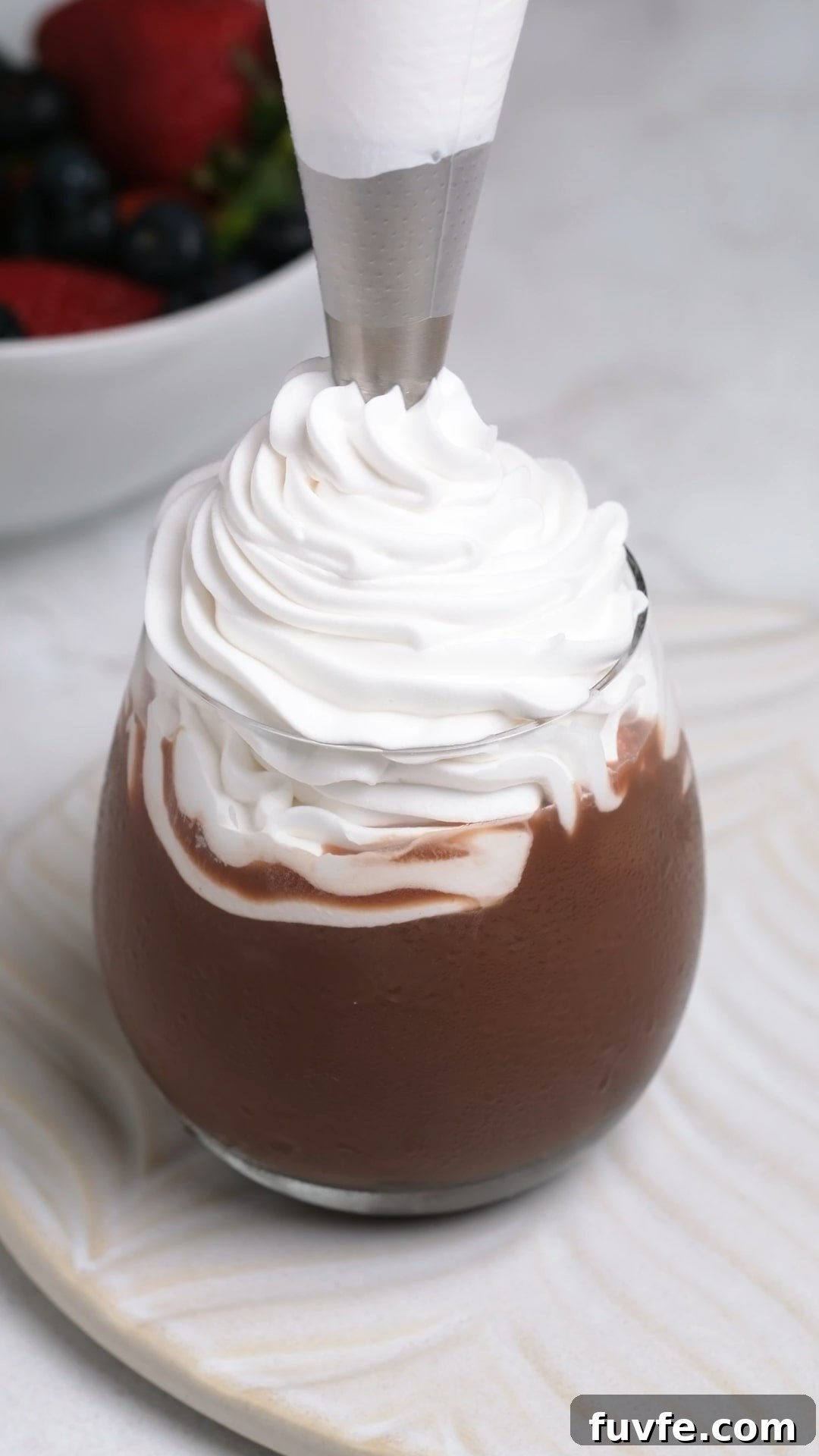 Bakery Tip: How to Make Stable Whipped Cream Frosting That Holds Up 10 Thick stabilized whipped cream frosting being piped into a glass.