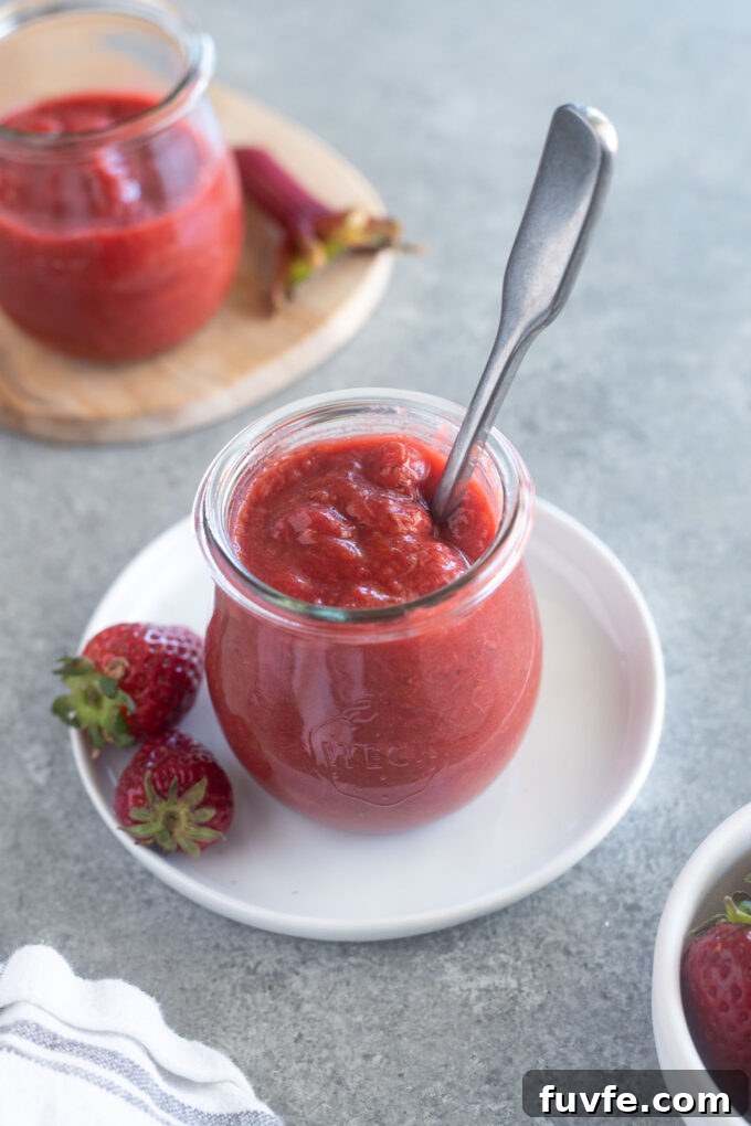 Strawberry Rhubarb Jam in a jar with spoon buried inside