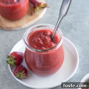 Strawberry Rhubarb Jam in a jar with spoon buried inside