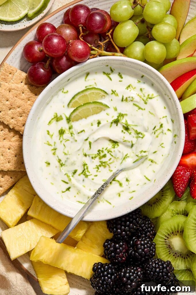 Key lime pie Greek yogurt dip in a bowl with zest and lime slices.