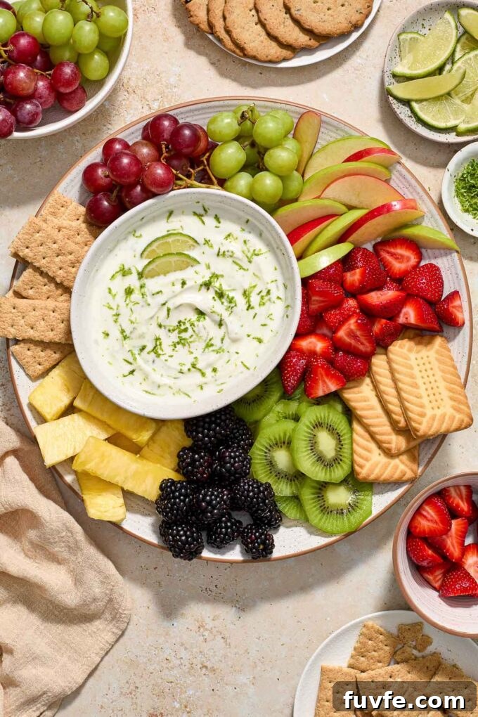 Key lime Greek yogurt fruit dip on a platter with fruits and graham crackers.