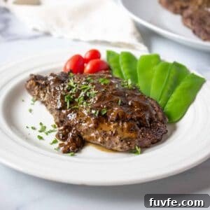 Elk Steak au Poivre Recipe: Peppercorn-Crusted Venison Steak 13 Elk steak topped with a brown sauce and freshly chopped parsley.