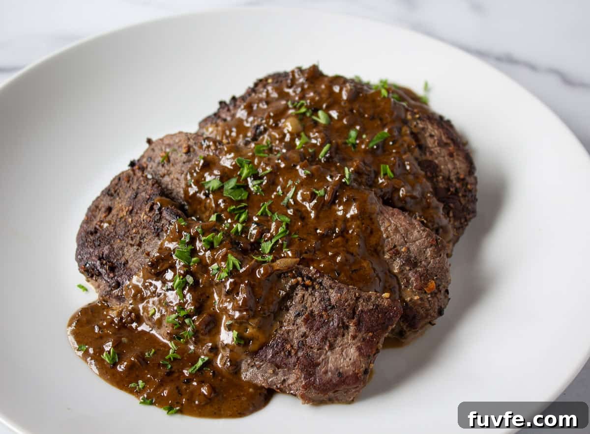 Elk Steak au Poivre Recipe: Peppercorn-Crusted Venison Steak 7 Elk steaks topped with a brown sauce and parsley.