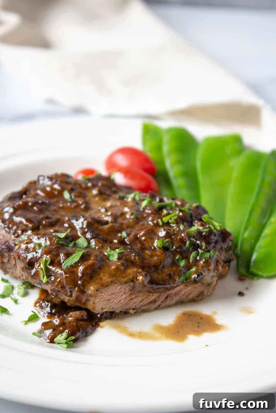 Elk Steak au Poivre Recipe: Peppercorn-Crusted Venison Steak 8 Sliced elk steak covered with a sauce.
