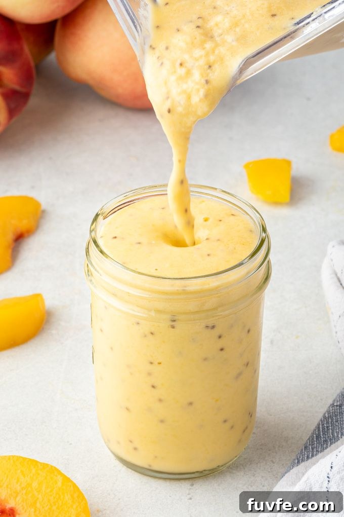 Peach smoothie pouring into a jar