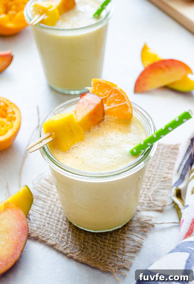 Peach mango smoothie in a jar with a straw