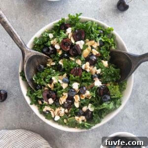 Kale, Cherry and Goat Cheese Salad Recipe 9 Cherry salad with salad servers digging into the bowl