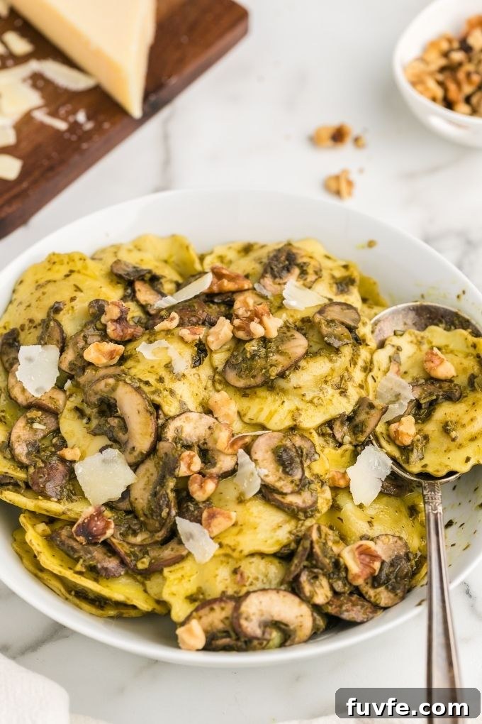 Mushroom ravioli in a white bowl with serving spoon