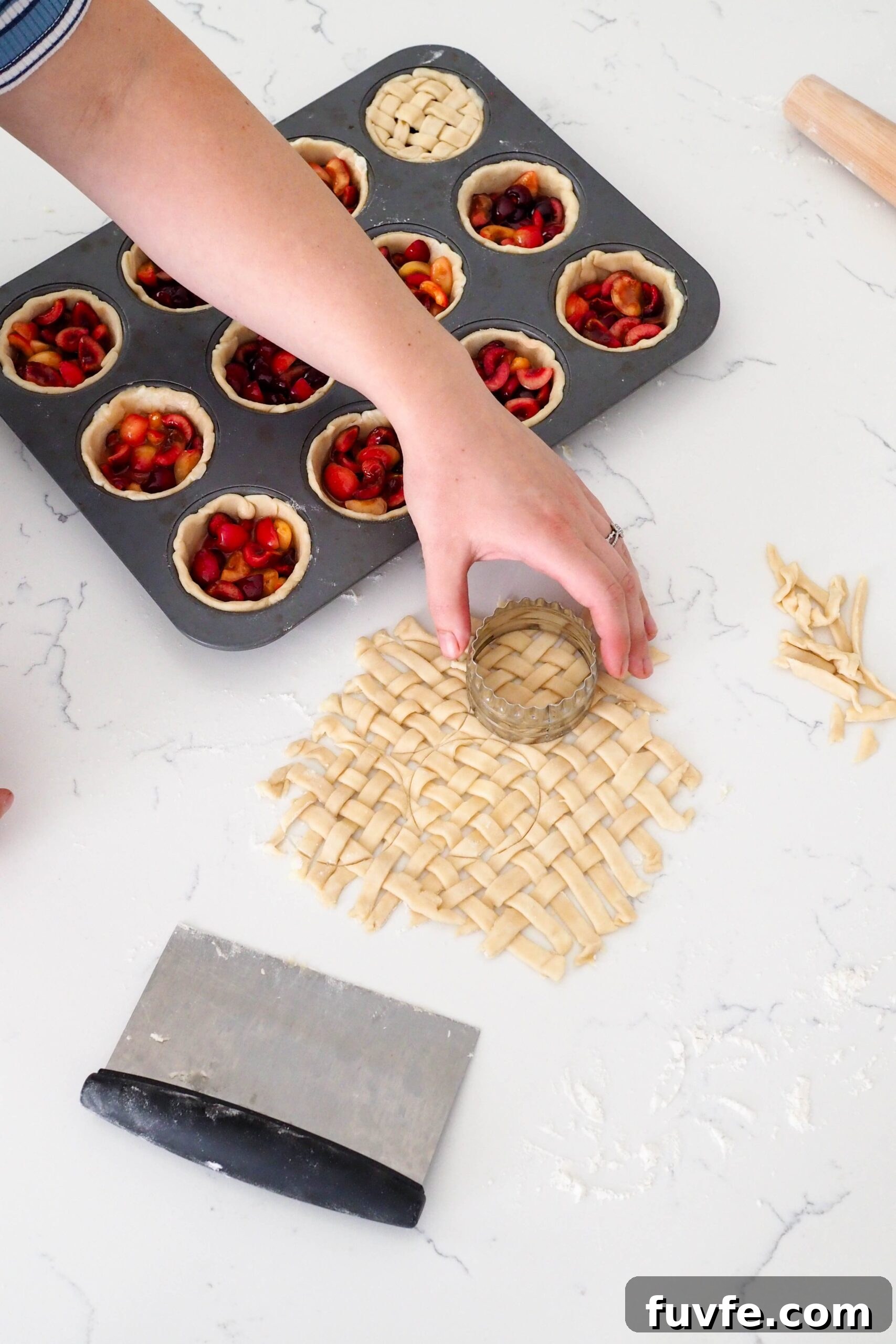 A hand uses a round cutter to cut out a small lattice.