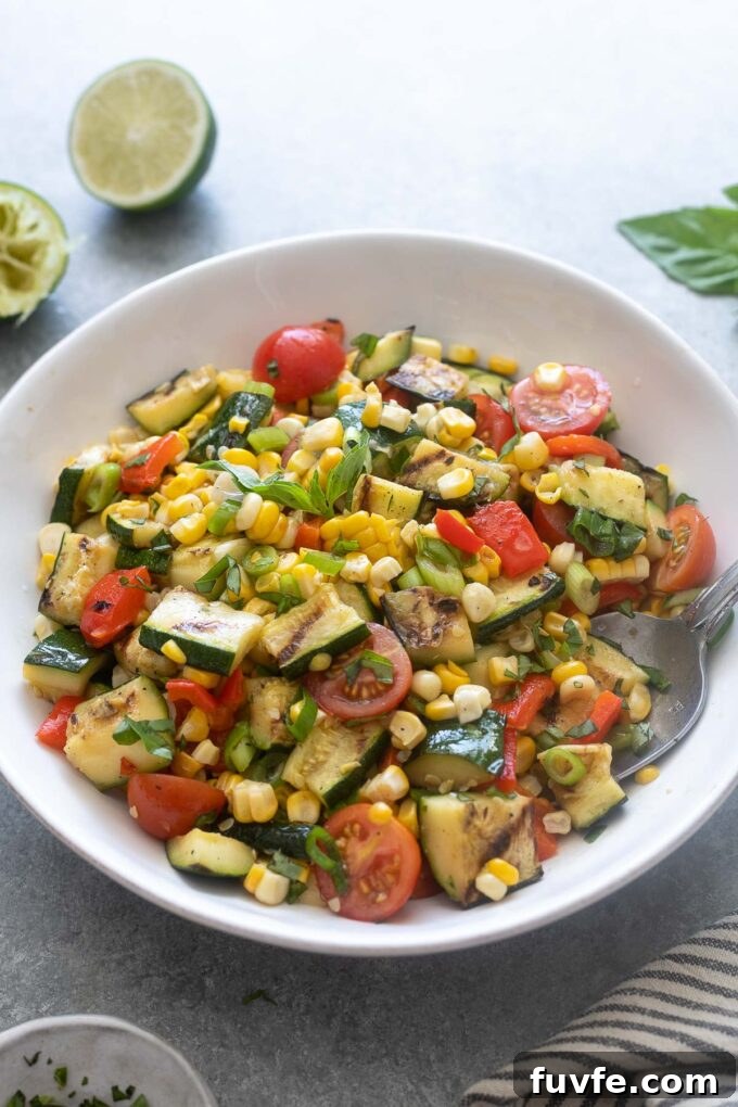 Grilled Zucchini and Corn Salad with Lemon Herb Dressing 5 Grilled zucchini and corn salad in a white serving bowl.