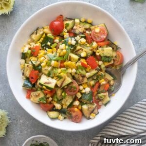 Grilled Zucchini and Corn Salad with Lime and Feta 7 Grilled zucchini and corn salad in a bowl with serving spoon.