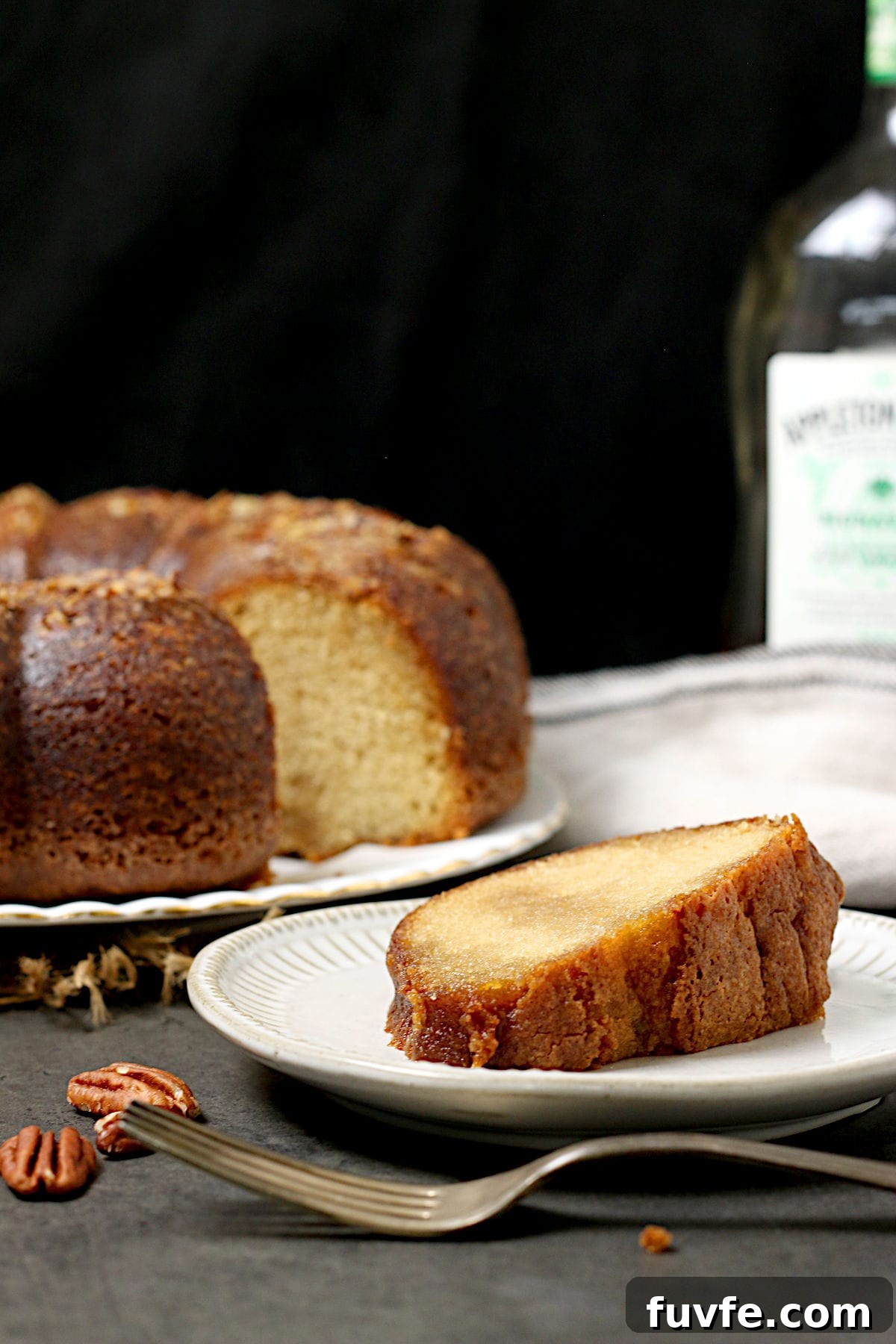 Homemade Caribbean Rum Cake with Toasted Pecans (No Mix) 5 A slice of Caribbean Rum Cake on a small white plate.