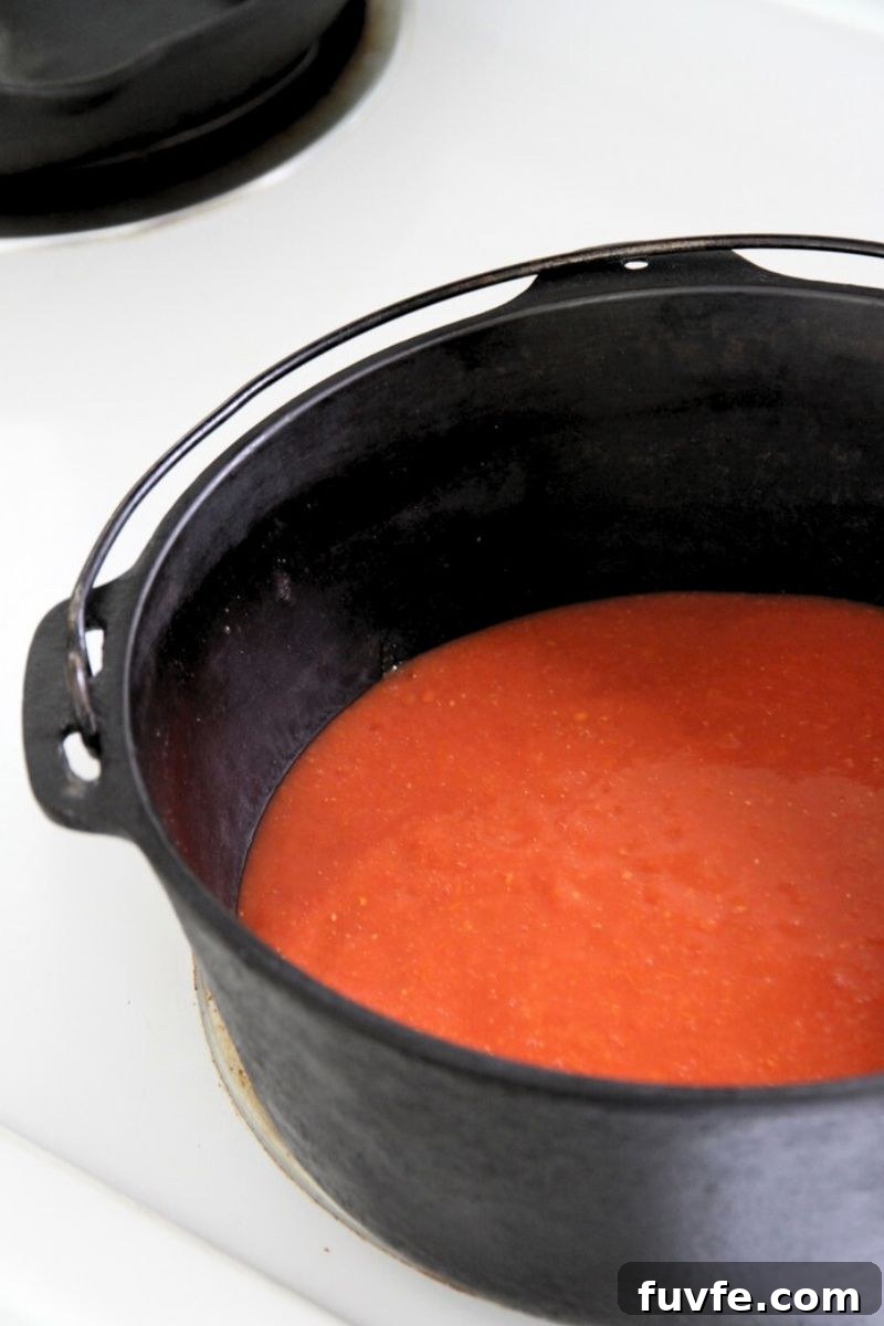 Tomato sauce simmering in a cast iron dutch oven. 