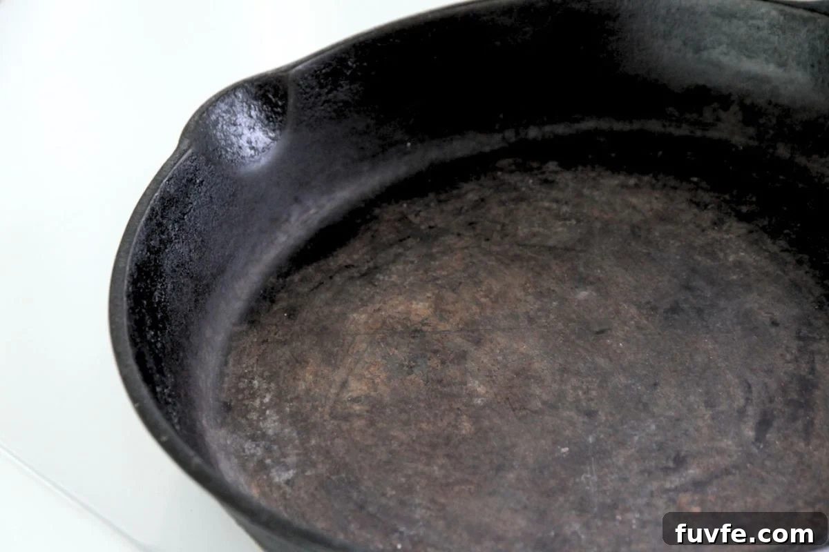 A cast iron pan with some orange iron oxide on the cooking surface.