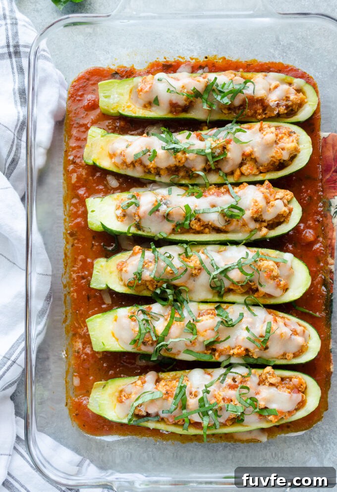 Chicken parmesan stuffed zucchini in a baking dish.