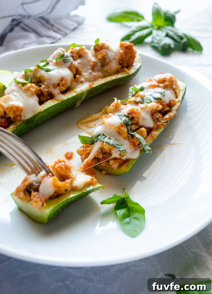 Chicken parmesan stuffed zucchini with cheese pull.