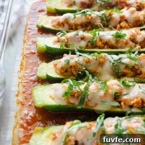 Chicken parmesan stuffed zucchini boats in a baking dish.