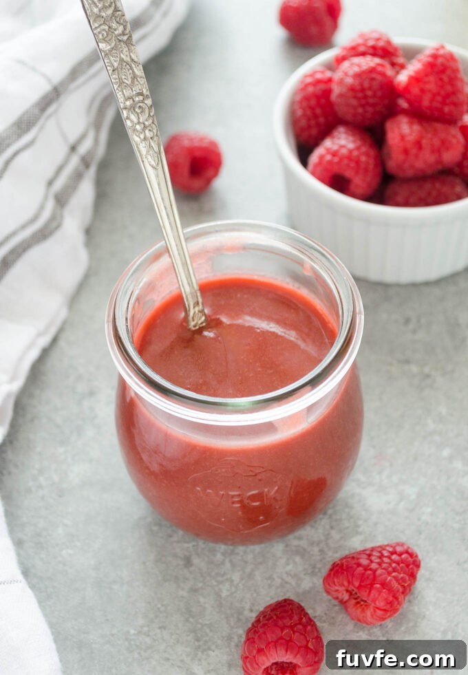 Homemade Raspberry Vinaigrette Recipe for Salads 2 Raspberry vinaigrette dressing in a jar with a spoon buried inside.