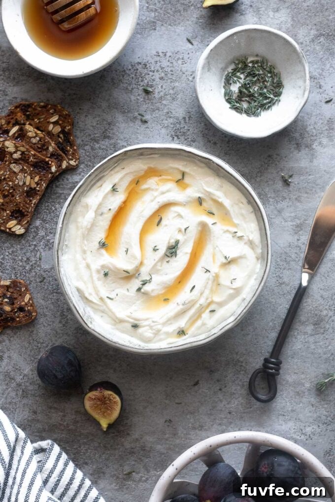 Bowl of whipped goat cheese with honey, thyme and figs surrounding.