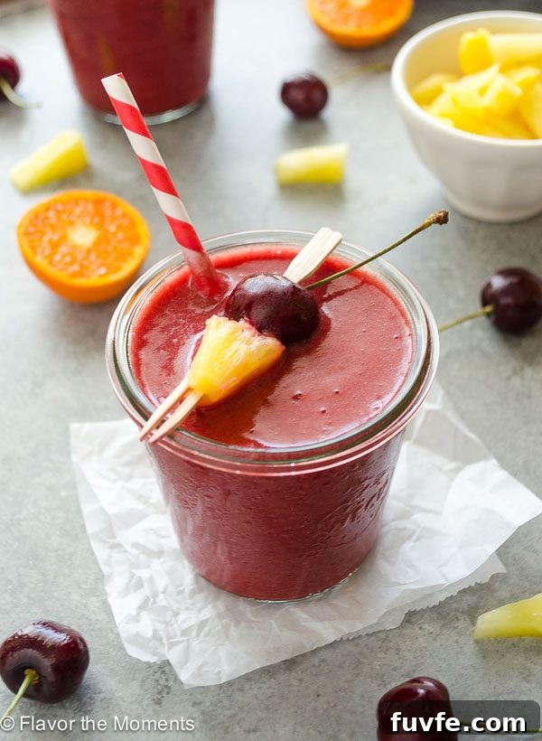 Cherry pineapple smoothie in jar with straw