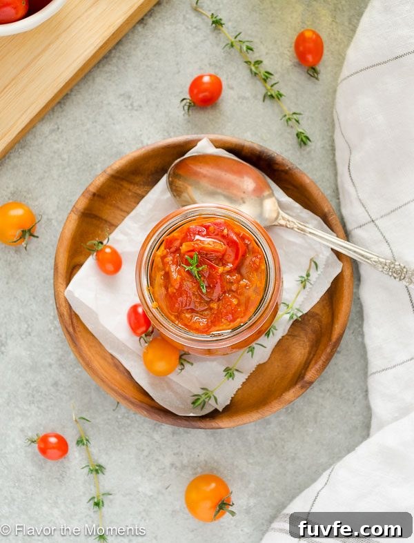 overhead shot of savory cherry tomato jam in jar on a teak plate