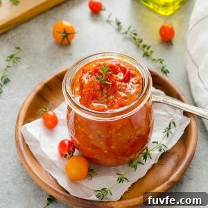Cherry tomato jam in jar with thyme on top
