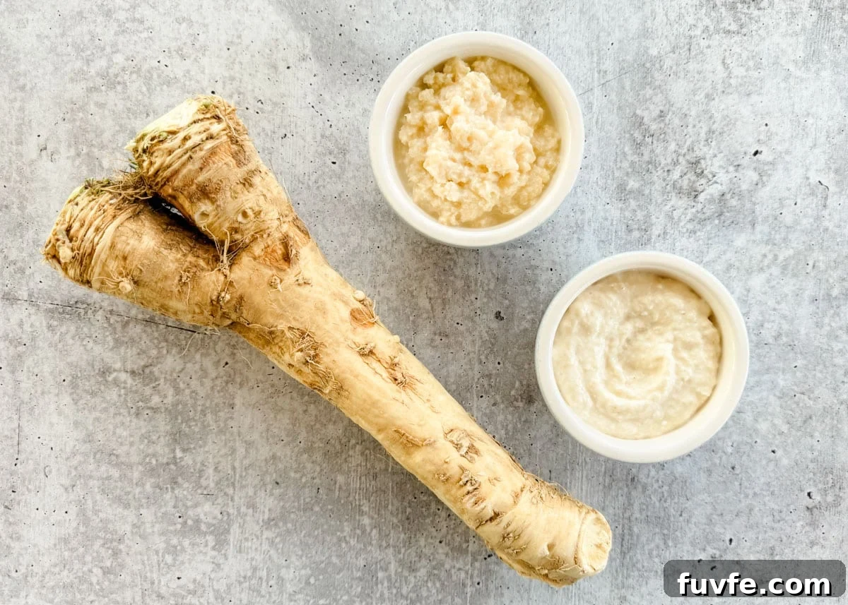 horseradish root, a bowl of prepared horseradish, and a bowl of horseradish sauce on a gray board
