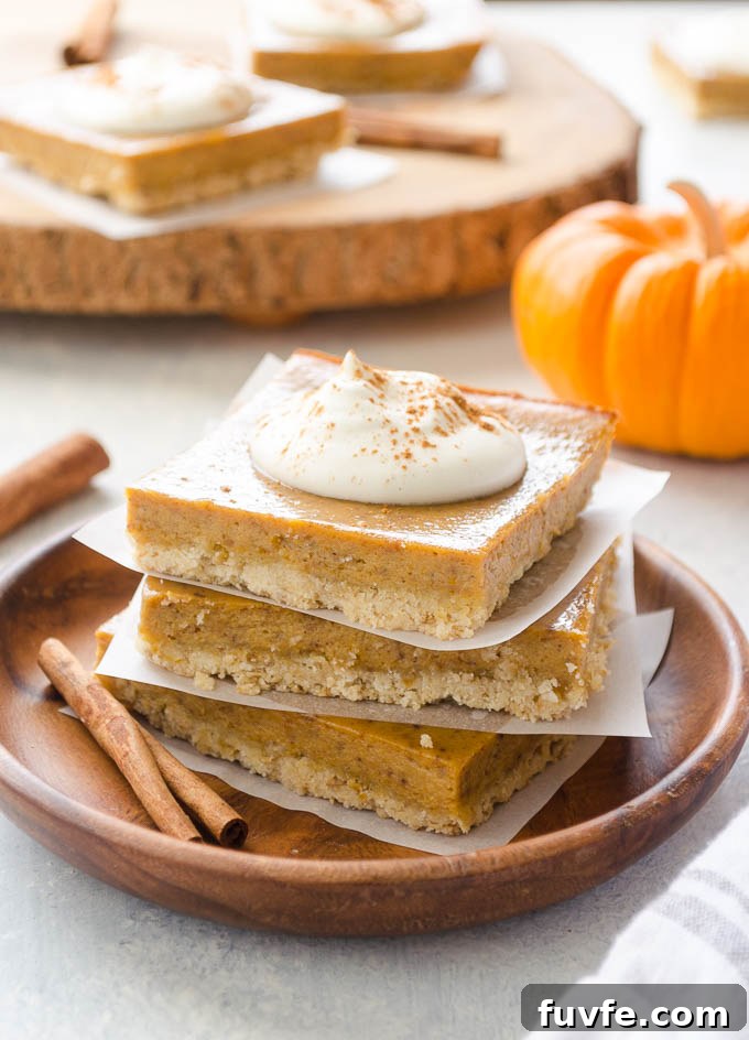 Pumpkin pie bars stacked on a teak plate
