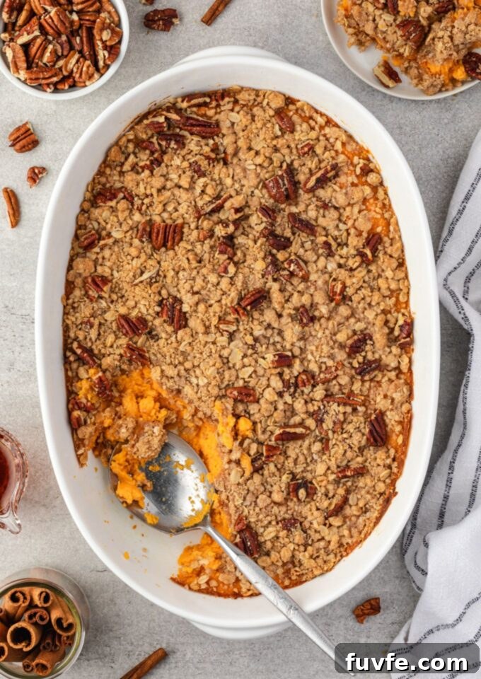 Sweet Potato Casserole with Brown Sugar Streusel 2 Spoon digging into sweet potato casserole with streusel topping