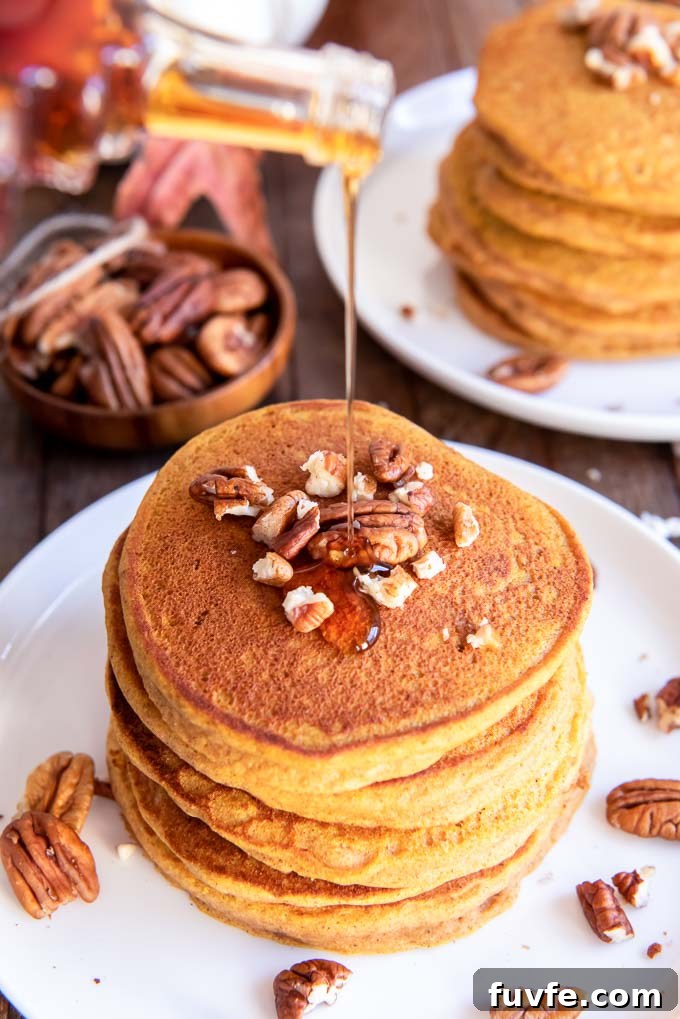Maple syrup pouring over pumpkin pancakes