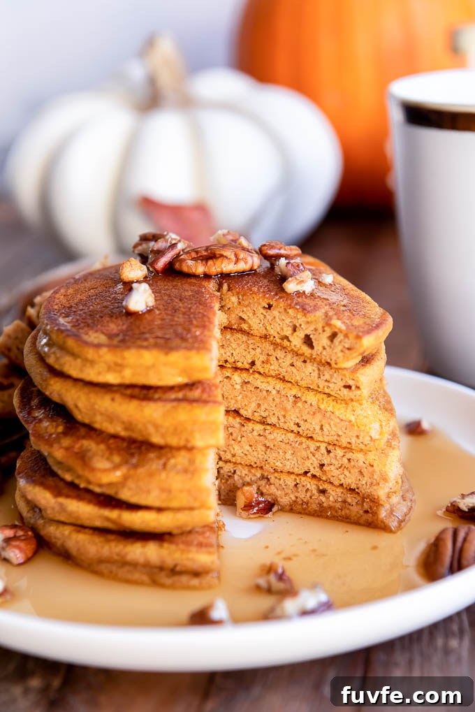 Stack of pumpkin pancakes on a plate with bite removed