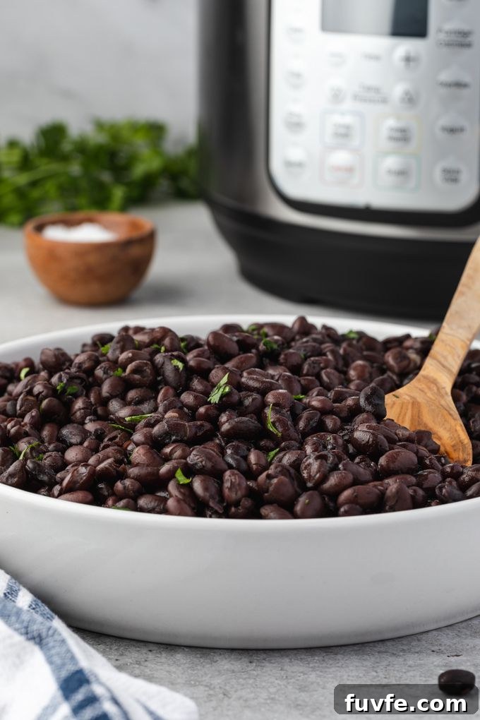 Instant pot black beans in a bowl with instant pot in the background