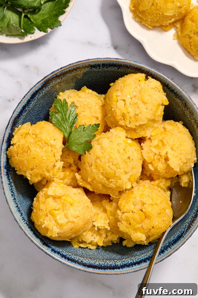 Sweet mexican corn cake scooped into balls in a blue bowl.