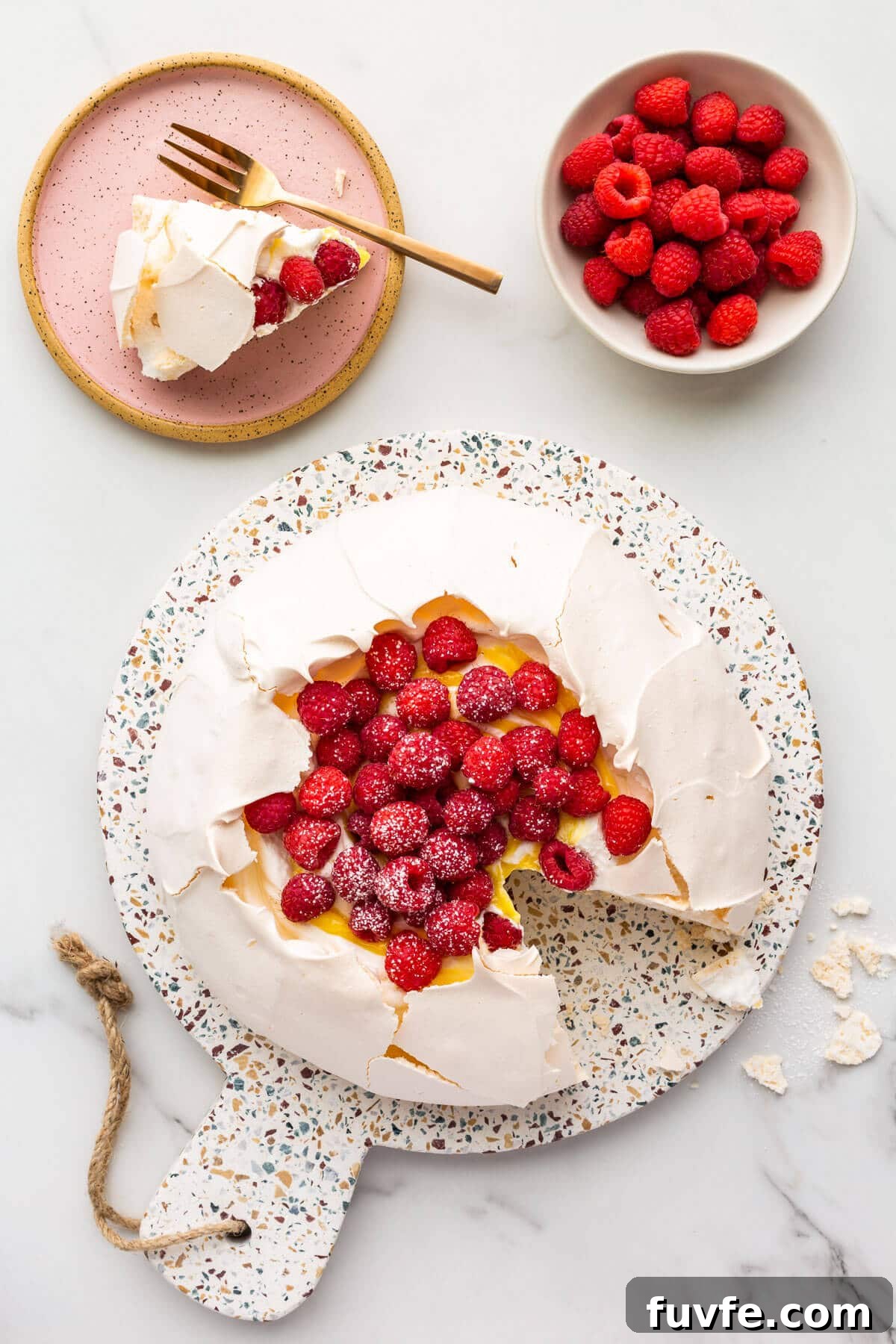 Classic Pavlova Recipe: Crispy Meringue with Fresh Fruit 10 Pavlova cake filled with whipped cream, lemon curd, and raspberries being served.