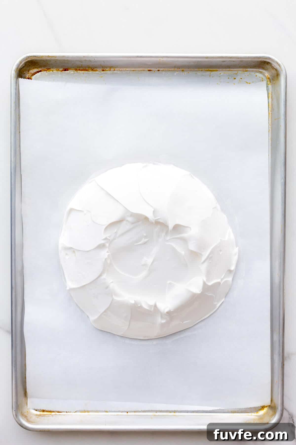 Classic Pavlova Recipe: Crispy Meringue with Fresh Fruit 5 Pavlova on parchment-lined sheet pan before baking in oven.