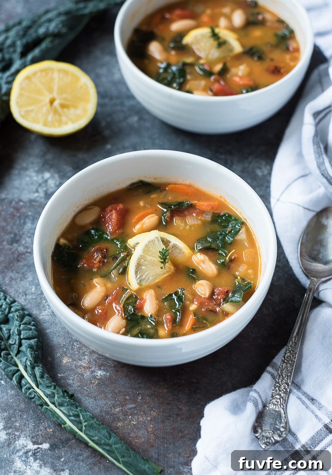 White Bean and Kale Soup Recipe with Garlic and Lemon 7 White bean and kale soup in a white bowl with a spoon alongside