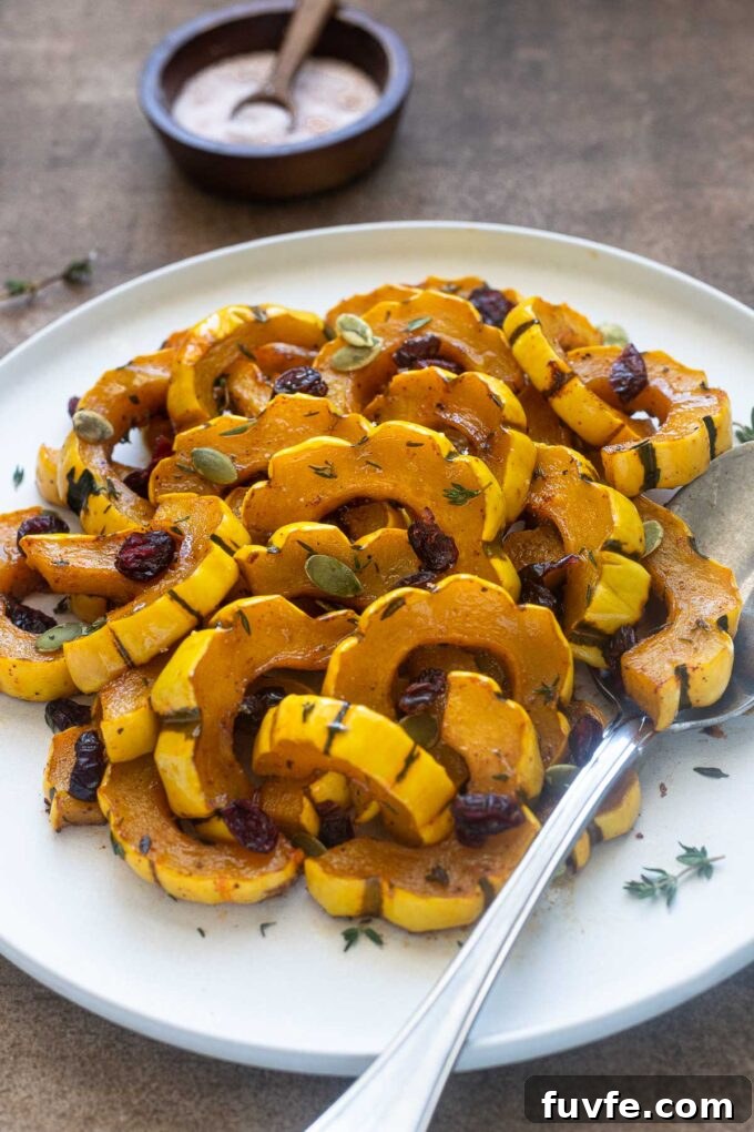 Maple roasted delicata squash on a plate with thyme leaves.