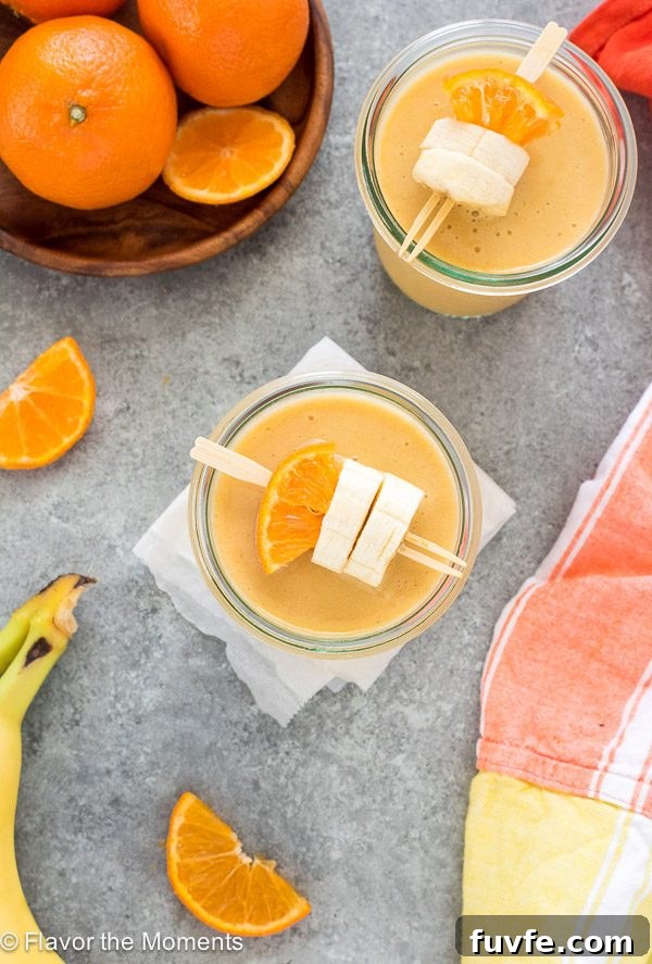 Creamy Orange Creamsicle Smoothie Recipe 5 Orange creamsicle smoothie in a jar with orange and banana skewered on a toothpick