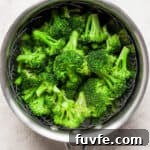 How to Steam Broccoli: Stovetop and Microwave Methods 12 Steamed broccoli in a saucepan with a steamer basket inside.