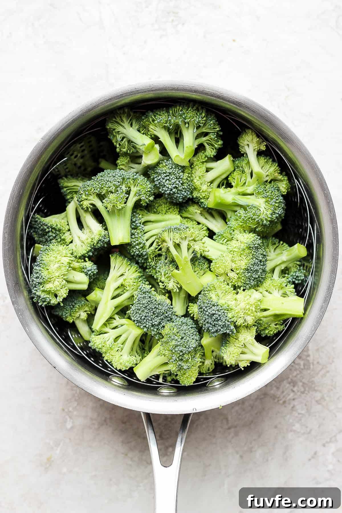 How to Steam Broccoli: Stovetop and Microwave Methods 5 Uncooked broccoli in a steamer basket.