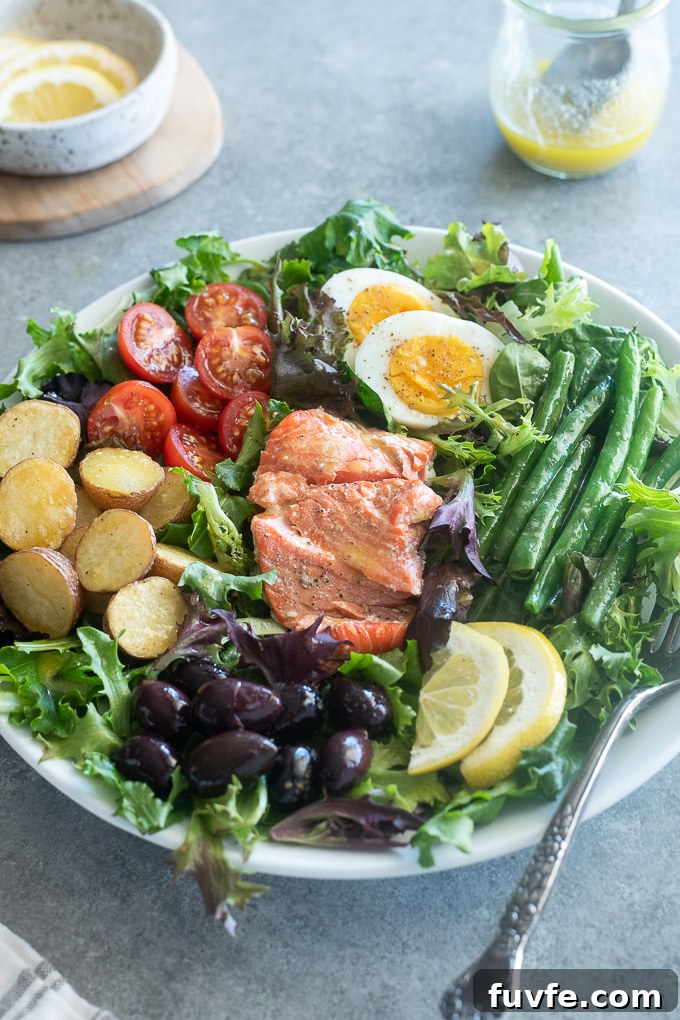 Salad nicoise with salmon on a white plate