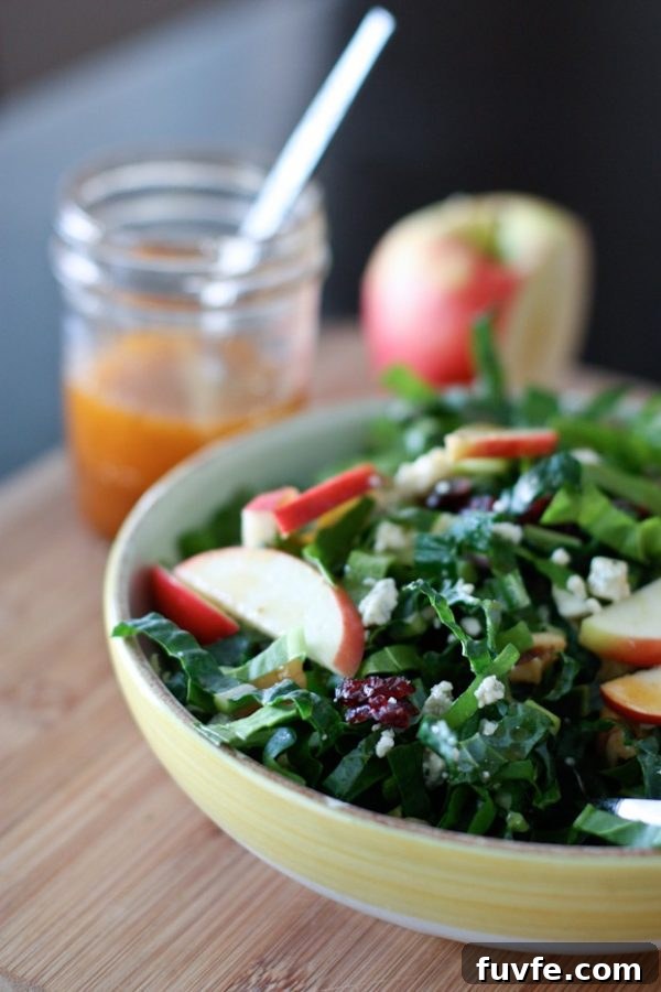 Kale and chard salad in bowl with apple slices on top