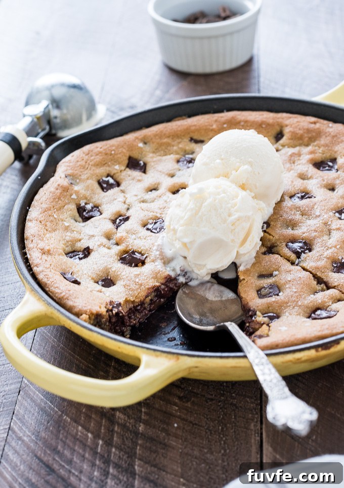 Gooey Cast Iron Chocolate Chip Skillet Cookie 7 Skillet chocolate chip cookie sliced in the pan with ice cream